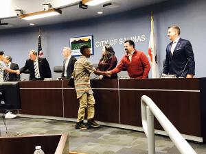 Youth shaking hands with Salinas City Council Members