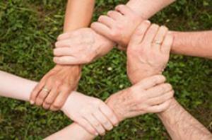 Photo of 6 people holding each other's wrists in a circle