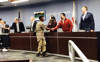 Youth shaking hands with Salinas City Council Members