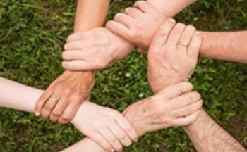 Photo of 6 people holding each other's wrists in a circle